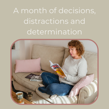Text reading "A month of decisions, distractions and determination." Woman sitting on a sofa reading copywriting books with a candle and cup of tea on the coffee table and a cat walking between the two on the floor.